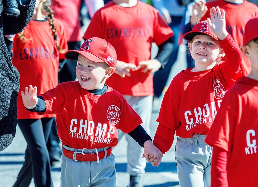 Ryan Barnowski and Lanna Coelho wave to friends and family while marching down Main Street in Warren Little League's 72nd annual Opening Day parade, Saturday.