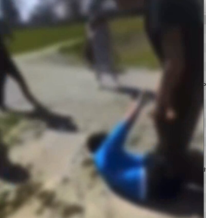 One of the Barrington High School students who fought with and beat another student after school on April 24 stands over the victim after he fell to the ground, as seen in an image from a cell phone video that recorded the incident and was shared on Snapchat.