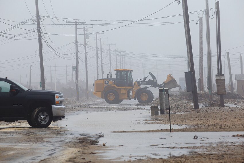 A highway department truck removes cobble from East Beach Road after one of the winter&rsquo;s strong storms.