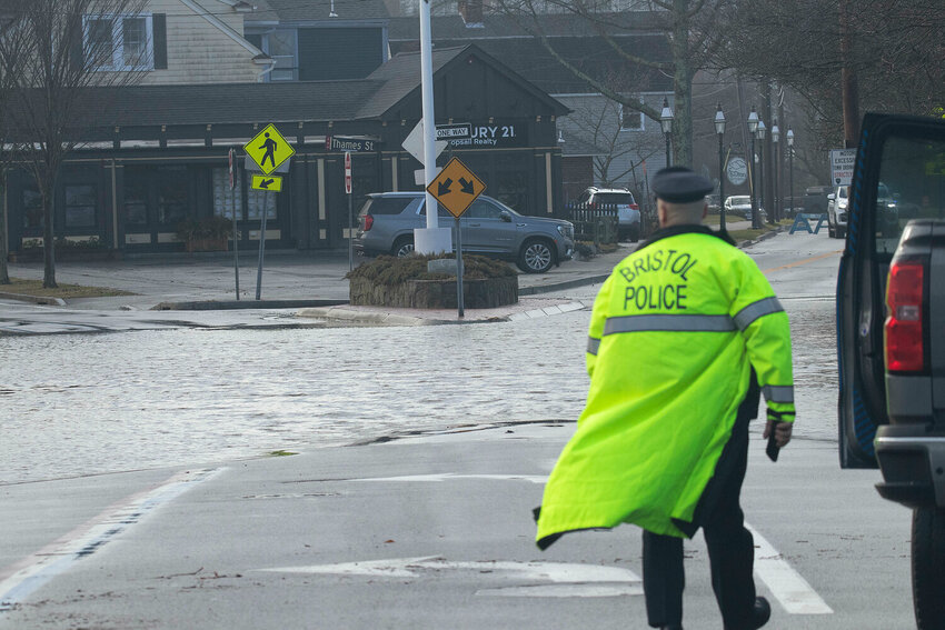 A Bristol Police officer surveys the intersection of Hope Street (Rt. 114) and Washington Street near the Sip N&rsquo; Dip earlier this year, where flooding regularly occurs and requires traffic diversion. This spot is one of the areas targeted by the state resiliency project targeting Route 114.