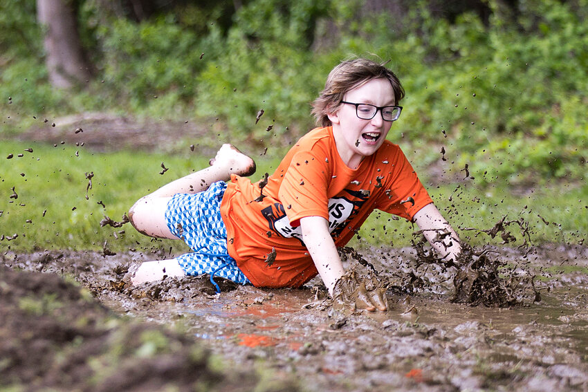 Finn Madden slides head first into the mud pit while participating in the Hampden Meadows Tough Tiger event, Sunday.