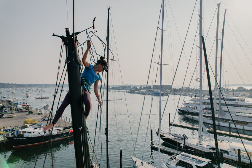 Cole Brauer performs rigging maintenance and work at the top of the mast.
