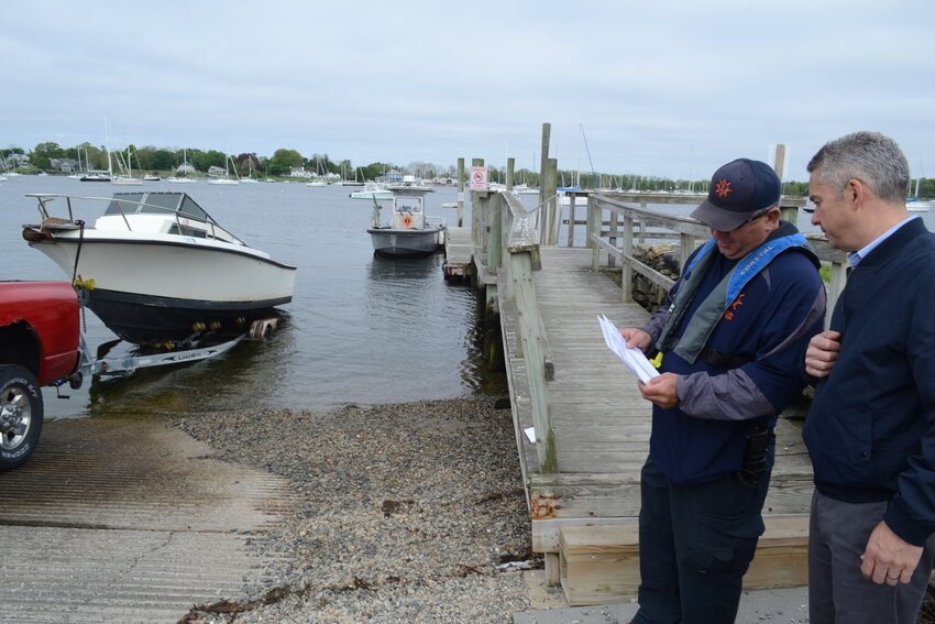 Harbormaster Gregg Marsili and Town Administrator Steven Contente discuss the plans for the new boat ramp as a truck (with great timing) unloads a boat into the water.