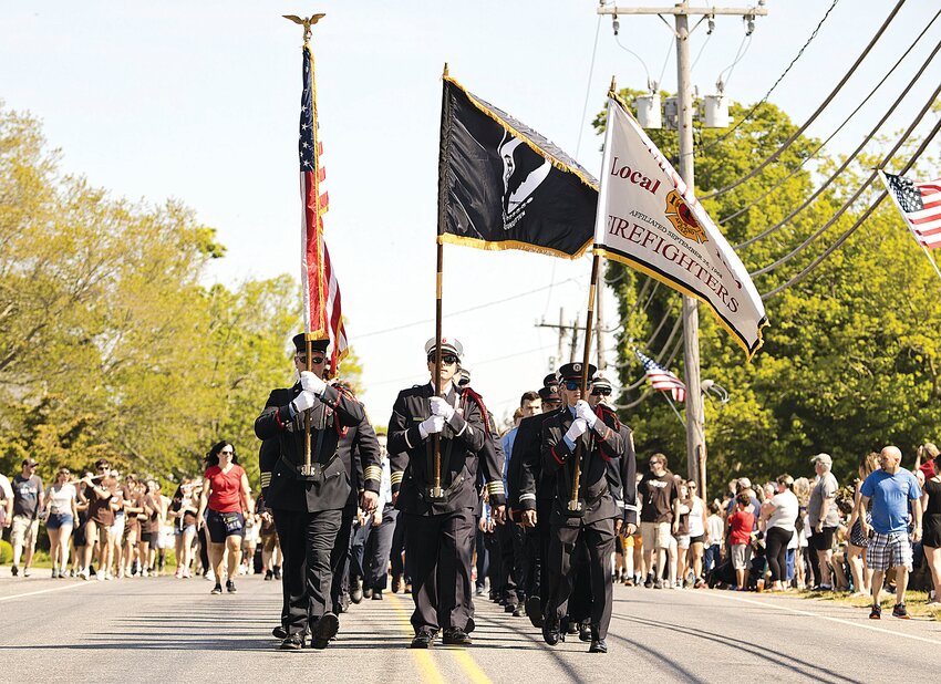 Marchers make their way down Main Road in last year&rsquo;s Memorial Day parade.
