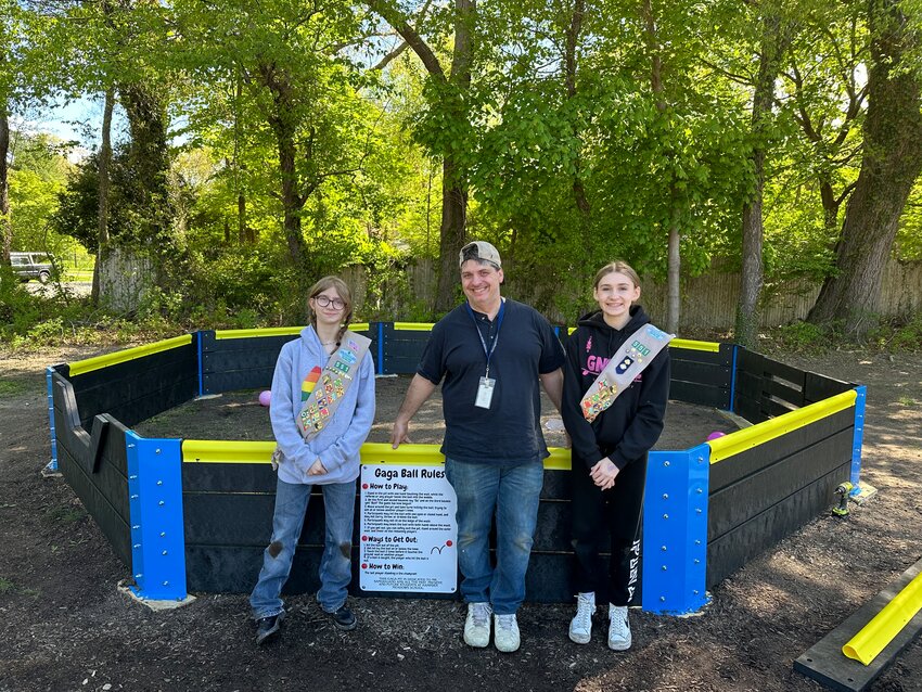 Eme Antone (left) and Alexandra Affronti (right) stand with Hampden Meadows School Principal Gino Sangiuliano next to the newly-completed Gaga Ball Pit.