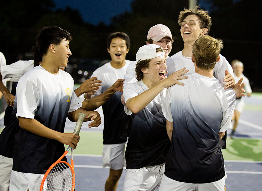 Members of the Barrington High School boys tennis team celebrate after winning the deciding match against LaSalle on Saturday night, June 1, at Slater Park in Pawtucket.