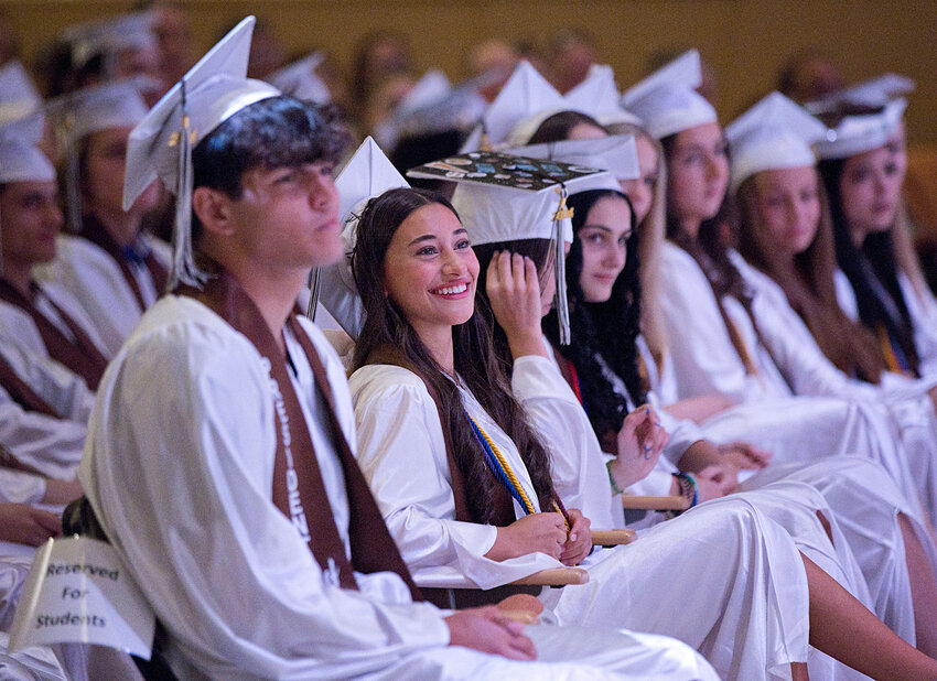 Salutatorian Avery Carvalho (second from left) smiles as Valedictorian Madison Plourde speaks at commencement Saturday morning.