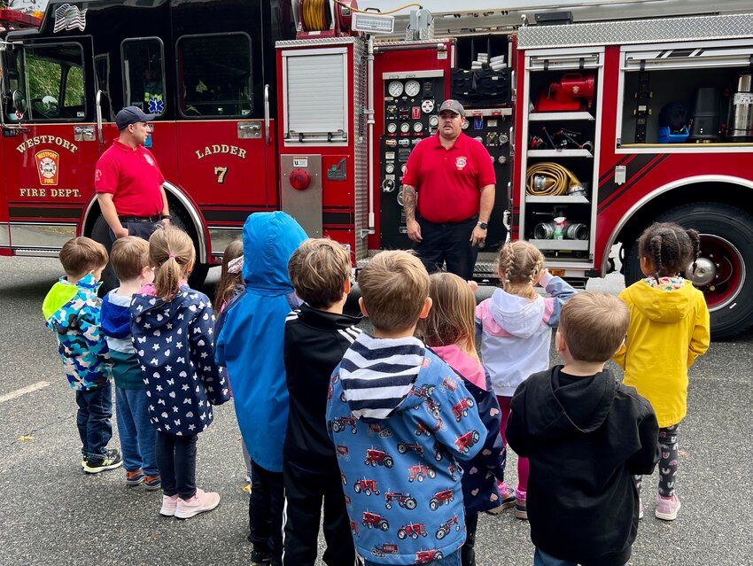 Students gather round as fire department members teach them about fire safety recently.