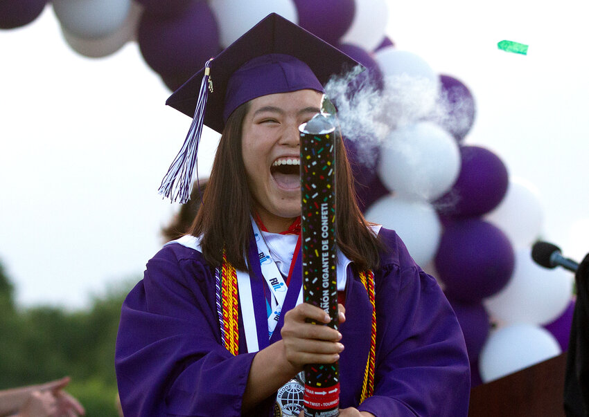 Elsa White opens up a can of confetti after receiving her diploma.
