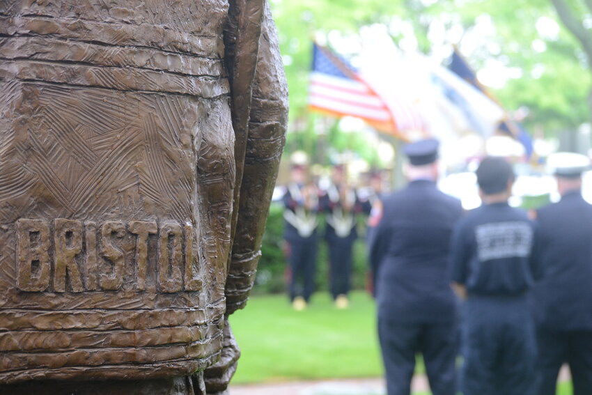 The new statue, designed by sculptor Victoria Guerina (who was in attendance), looks over the shoulders of firefighters and EMS personnel during Sunday&rsquo;s annual Firemen&rsquo;s Memorial at Bristol Firemen&rsquo;s Memorial Park.