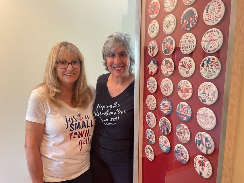 Nina McCarthy and Sara Jane Soboleski with the display case for McCarthy&rsquo;s complete collection of July 4th commemorative buttons. The case, which has space for 11 more buttons, was designed by Soboleski and Patty McCobb of Allerton Framing, a birthday gift to Nina from her husband Pat.