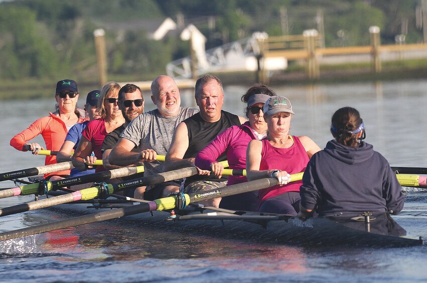 Rowers in a mixed masters boat lean into their stroke during an East Bay Rowing practice session along the Barrington River and Hundred Acre Cove early on a recent weekday morning. At this time of the year, teams launch their boats at 5:30 a.m. for a 90-minute workout.