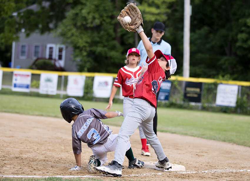 Jacob Campano attempts to complete a put-out at first base for the EP Central club in its Silva Minor Baseball All-Star Tourney game last week against Warren.