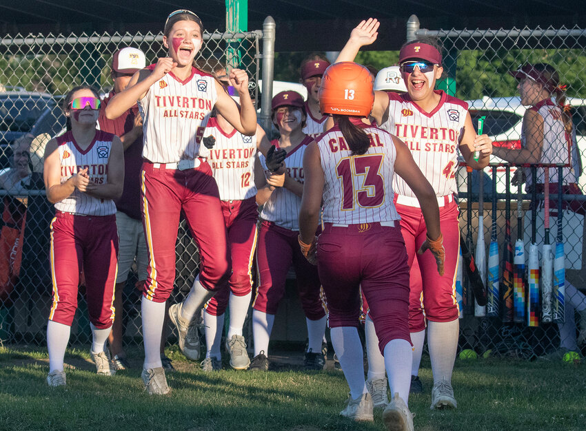 Lexie Fredricks (left) and Abbie Coutu (right) celebrate with Mia Cabral (middle) after she hit an inside the park home run in the fifth inning.