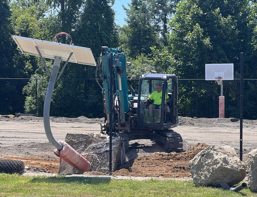 Carl Zukunft, of Maisano Brothers Paving, removes a basketball hoop at Chianese Park on Tuesday, July 2.