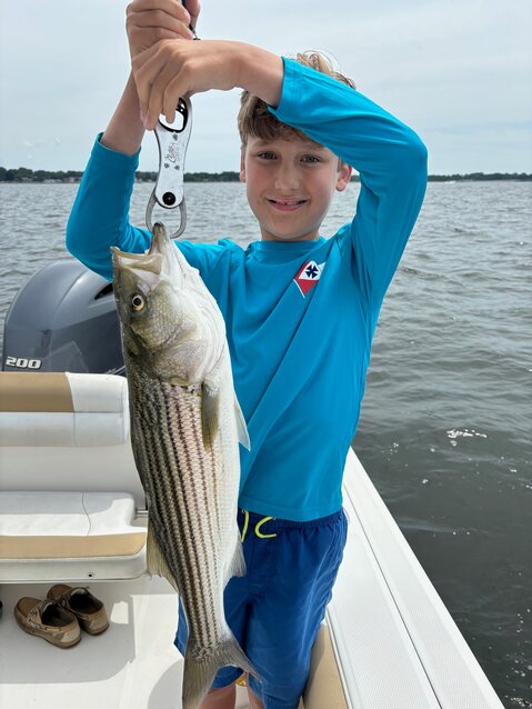 Jonah Tracy of Barrington, with a striped bass caught fishing with his father Mark, using a Kastmaster lure in 20 feet of water off Bristol between Colt State Park and Poppasquash Point.