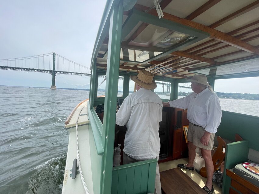Capt. Mike Martel is at the helm approaching the Mt. Hope Bridge, while his partner, Capt. Tom Bradford, looks on.