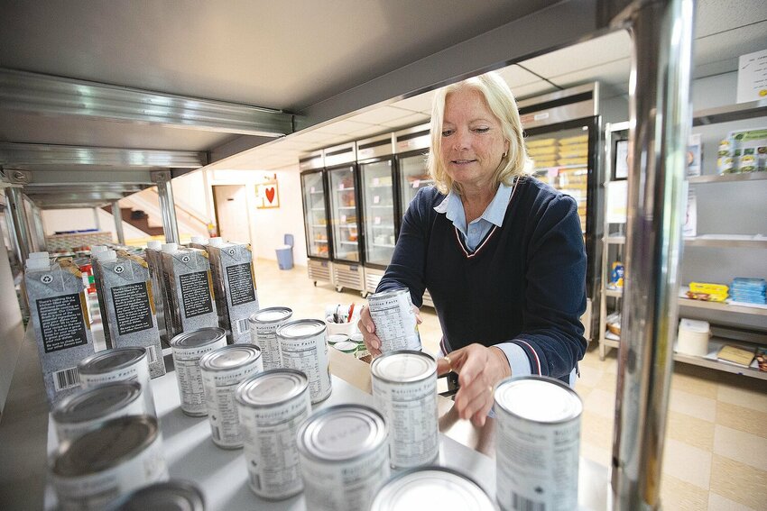 Volunteer Holly Lippert stocks the shelves at the Little Compton Food Bank. The bank serves 60 households a week.