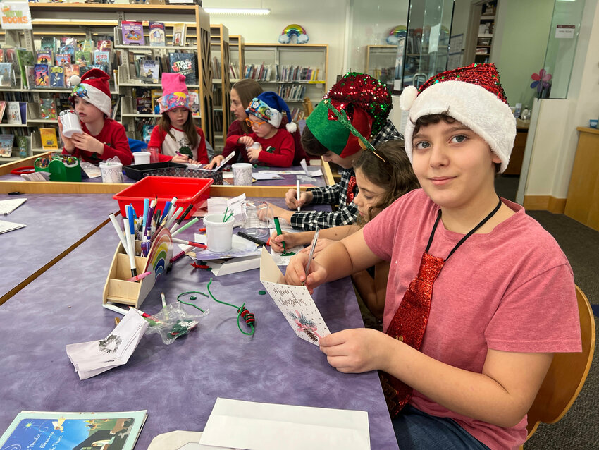 Jacob Rocha, 10, (right) and others make Christmas cards at Rogers Free Library on Friday morning.&nbsp;