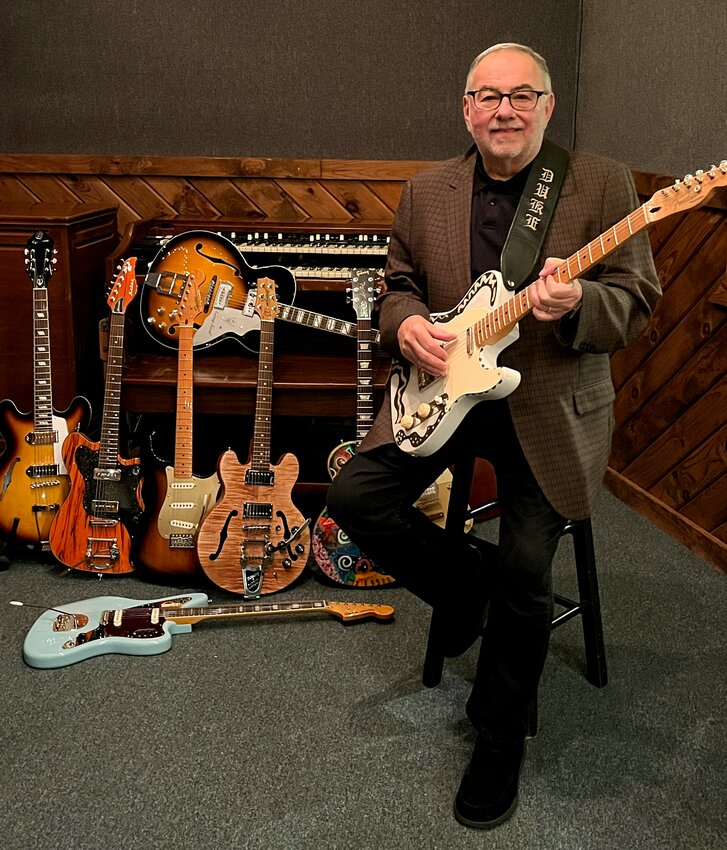 Duke Robillard sits with his many instruments.
