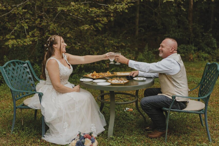 Kim (left) and Tim Gray (right) eat dinner outside on their wedding day.