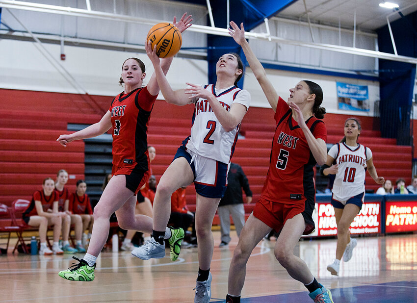 Portsmouth High&rsquo;s Molly Hurd splits a pair of Cranston West defenders while breaking away toward the hoop during Wednesday&rsquo;s preliminary Division I playoff game.