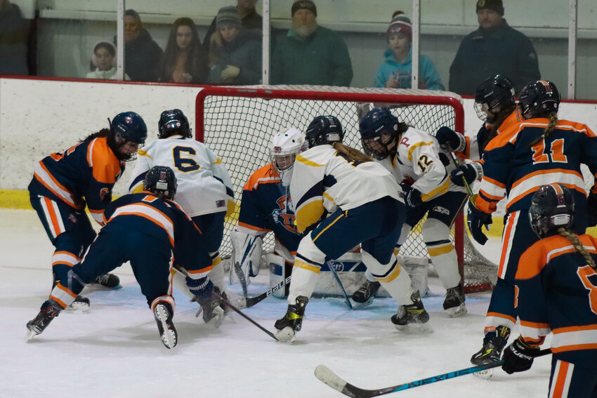 Three East Bay players try to slam the puck past the Northern RI Yeti goalie during the second game in the playoff series.
