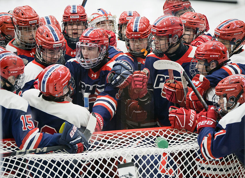 Portsmouth High hockey players rally in their goal before facing off against East Greenwich in the Division II championship game on Sunday.