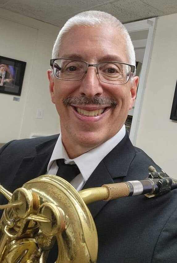 Bob Hassan, baritone saxophonist, flutist, school teacher and group exercise instructor, smiles while holding his saxophone &mdash; his chosen instrument.