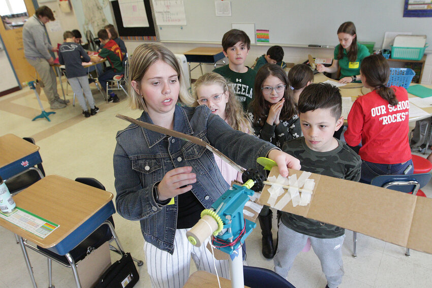 Roger Williams University student Caitlin Brennan (left) sets up a turbine for testing with students&nbsp;Logan Armillotto (right) and others.&nbsp;