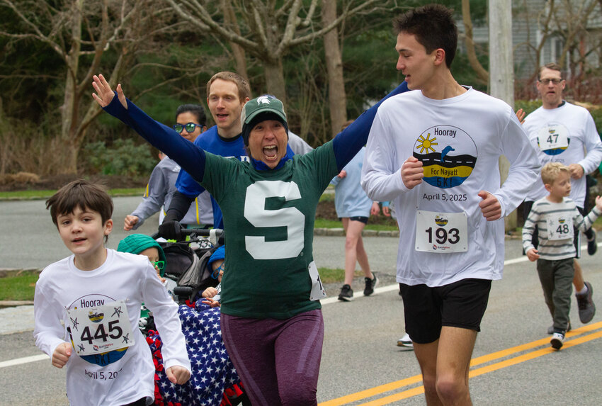 A runner smiles for the camera during the start of the annual Nayatt 5K Road Race on Saturday.