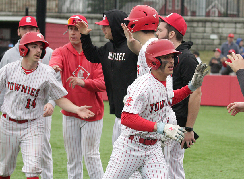 Teammates celebrate with Tim Robitaille (left) and Aidan Martins after they scored in the first inning.&nbsp;