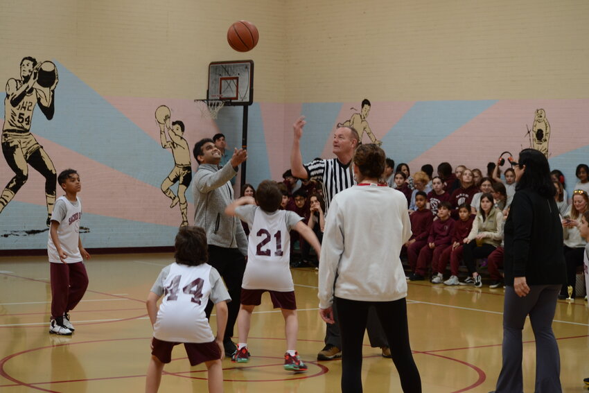 Frank Fogarty tosses the opening tip at the staff vs. student basketball game to celebrate the end of the season. Fogarty started the basketball team at Sacred Heart three years ago.