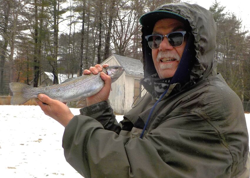 Gary Vandemoortele with a 14 inch rainbow trout caught at Spring Grove Pond, Chepachet on a cold and snowing opening day on Saturday.&nbsp;