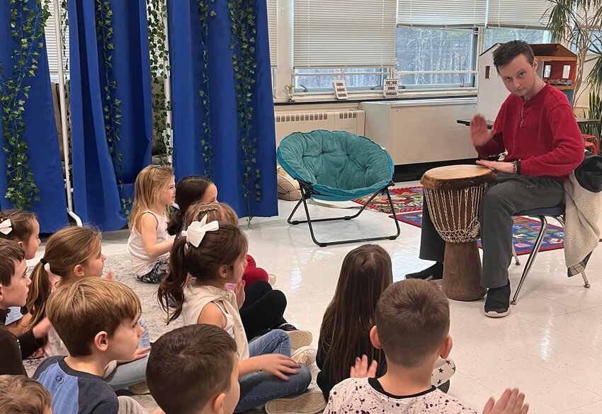 Thomas Harrington teaches drumming to students at the Macomber School several years ago.
