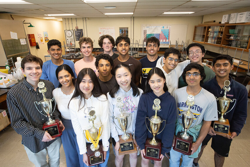 Some members of the Barrington High School Science Olympiad team pose for a photo inside a science classroom. The local team won the state Science Olympiad championship and will compete in nationals in May. Barrington High School has won 15 straight state championships.