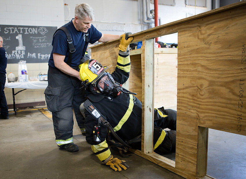 Lt. Pete Withers teaches Rick Amicucci a &quot;swim move&quot; to effectively crawl through a small opening in a wall during the recent Warren Fire Department training seminar led by Firehouse Training Plus, owned by former local volunteer firefighters.