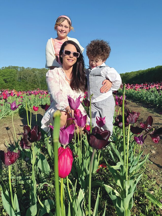 Sophia Carpenter (bottom left) enjoys a day of strawberry picking at Sweet Berry Farm with her children, Alexa (top left) and TJ, as they pose for a family photo.