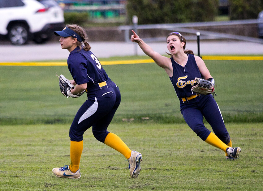 Centerfielder Ace McCoy points toward the runner as Anna Aguiar (left) fields a hit.
