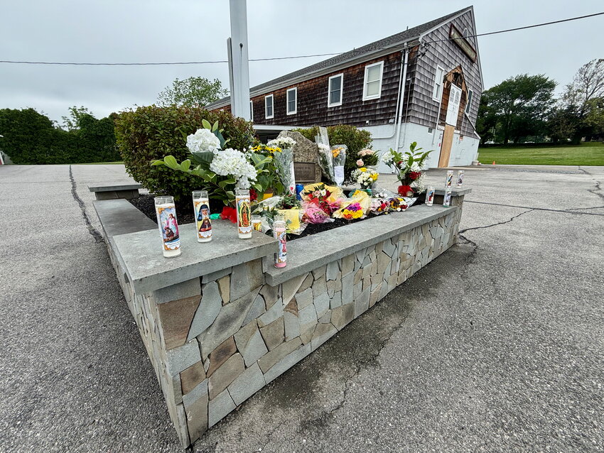 A memorial full of flowers and prayer candles in memory of the deceased 15-year-old is set up in front of the Portuguese American-Citizens Club building at 35 Power St. Behind it, you can see the second-floor entrance where a landing at the top of a set of stairs gave way during a graduation party Saturday night. Both the landing and stairs have since been removed.
