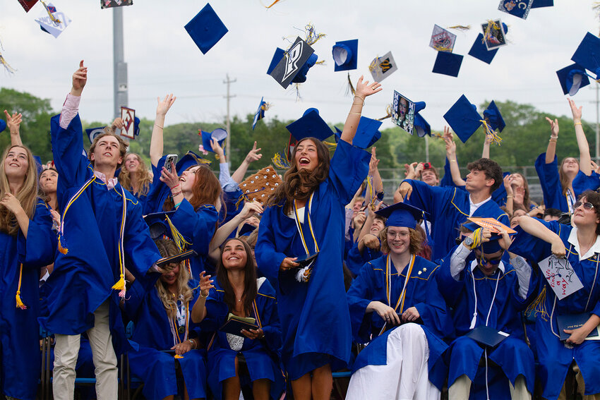 Members of the Barrington High School Class of 2025 toss their caps into the air after graduating on Sunday, June 8, at Victory Field.