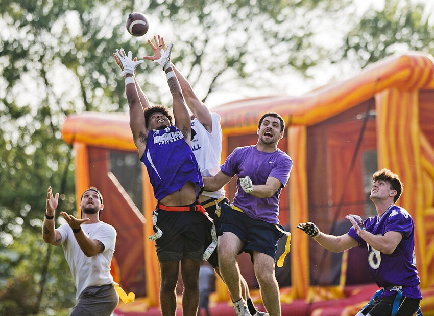 AJ Brooks rises up among a group of former Mt. Hope High School football players to make a catch during their annual flag game played this year at Burr's Hill Park in Warren Saturday night, June 21.