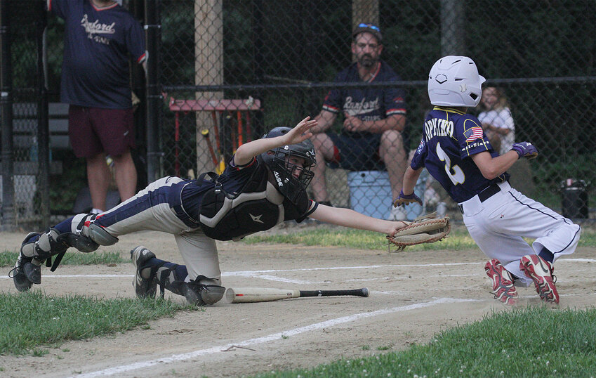 Rumford 11U All Stars catcher Jameson Bazar attempts to tag out Barrington runner Rocco Coppolino at the plate.