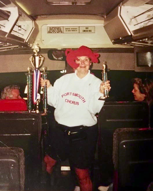 Kate Grana shows off trophies the Portsmouth High School chorus won during a festival at Hershey Park in Pennsylvania in 2002 or 2003. Her sense of humor and joyful personality were among the qualities that endeared her to students. This photo was shared by a former chorus member, Ryan Spero.