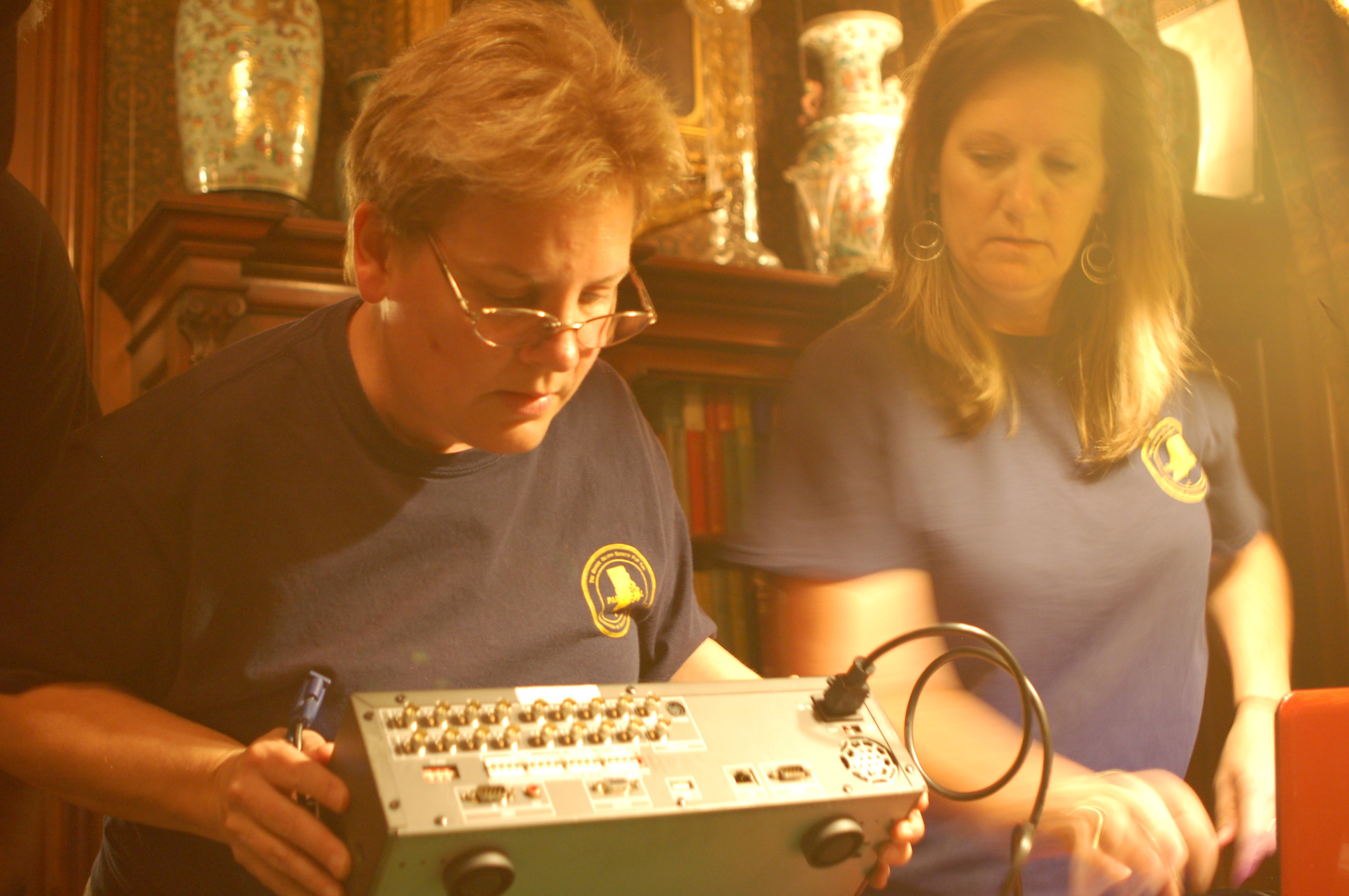 Julie DeMay hooks up the monitoring hardware while Wendy Thatcher looks on.