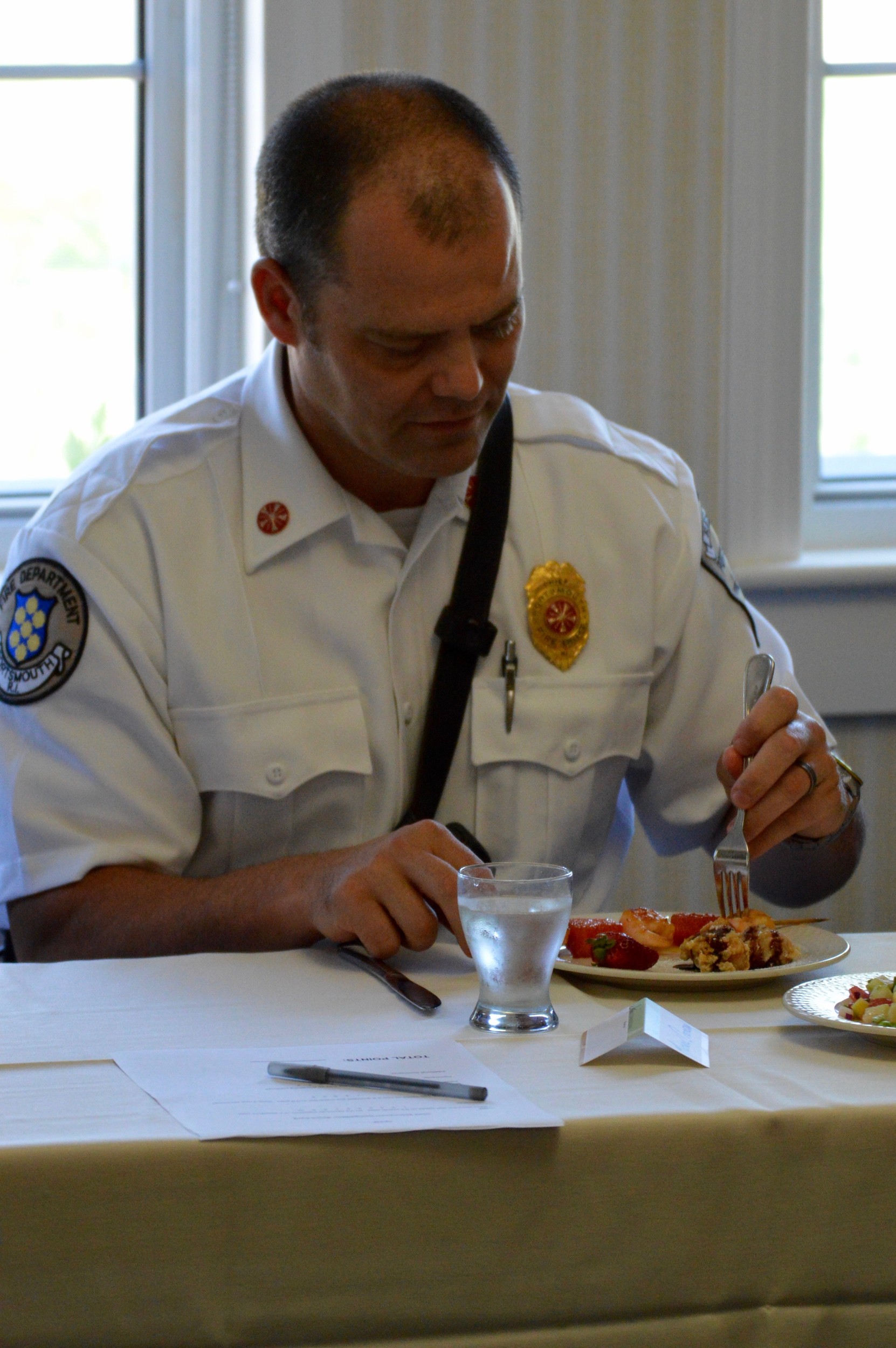 One of the judges, Fire Chief Michael Cranson, samples Lt. Steve Hoetzel’s grilled shrimp-and-watermelon skewers.