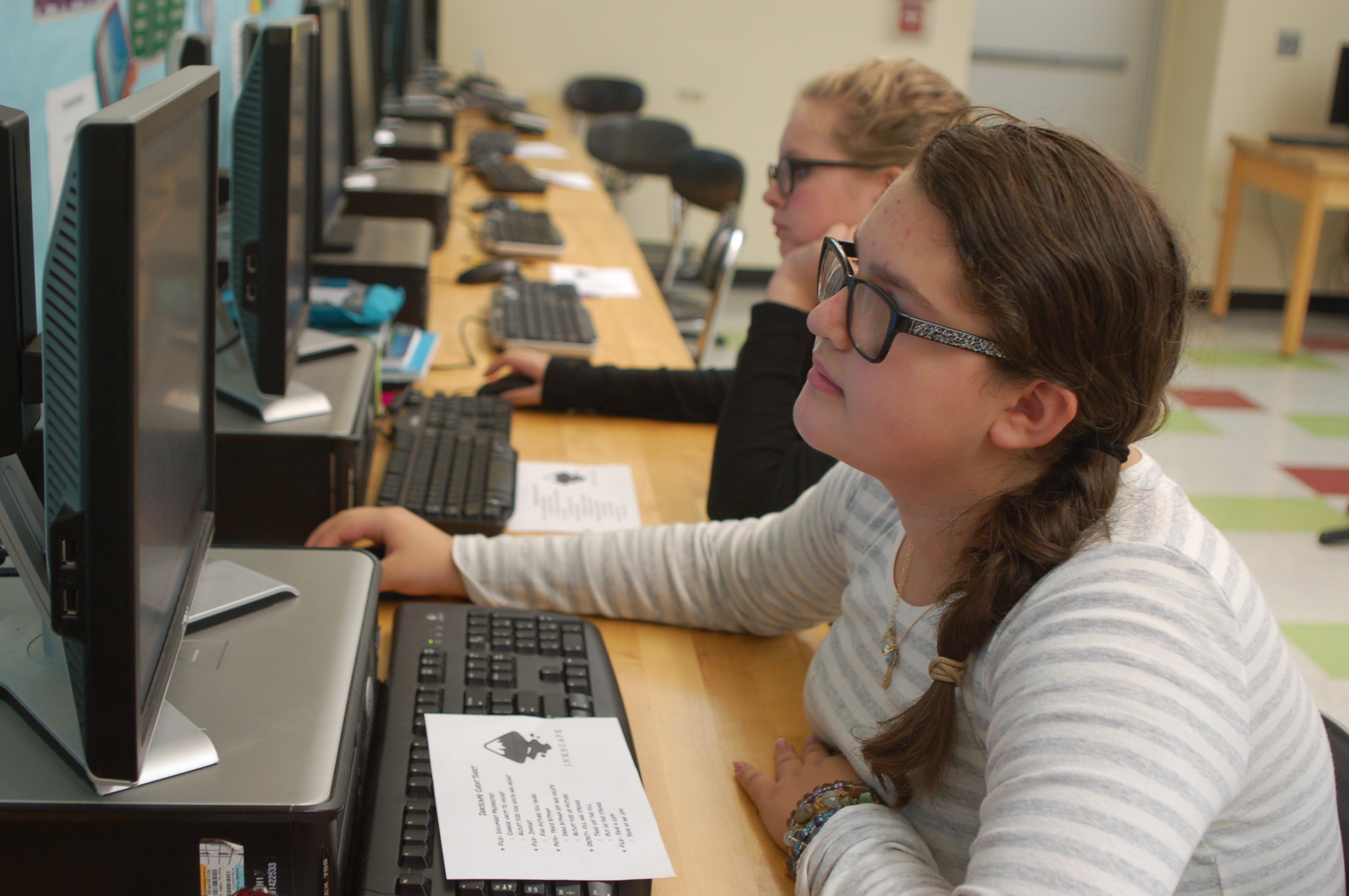 Caroline Florence (front) and Ava Spinks, prep their sticker designs on Inkscape.