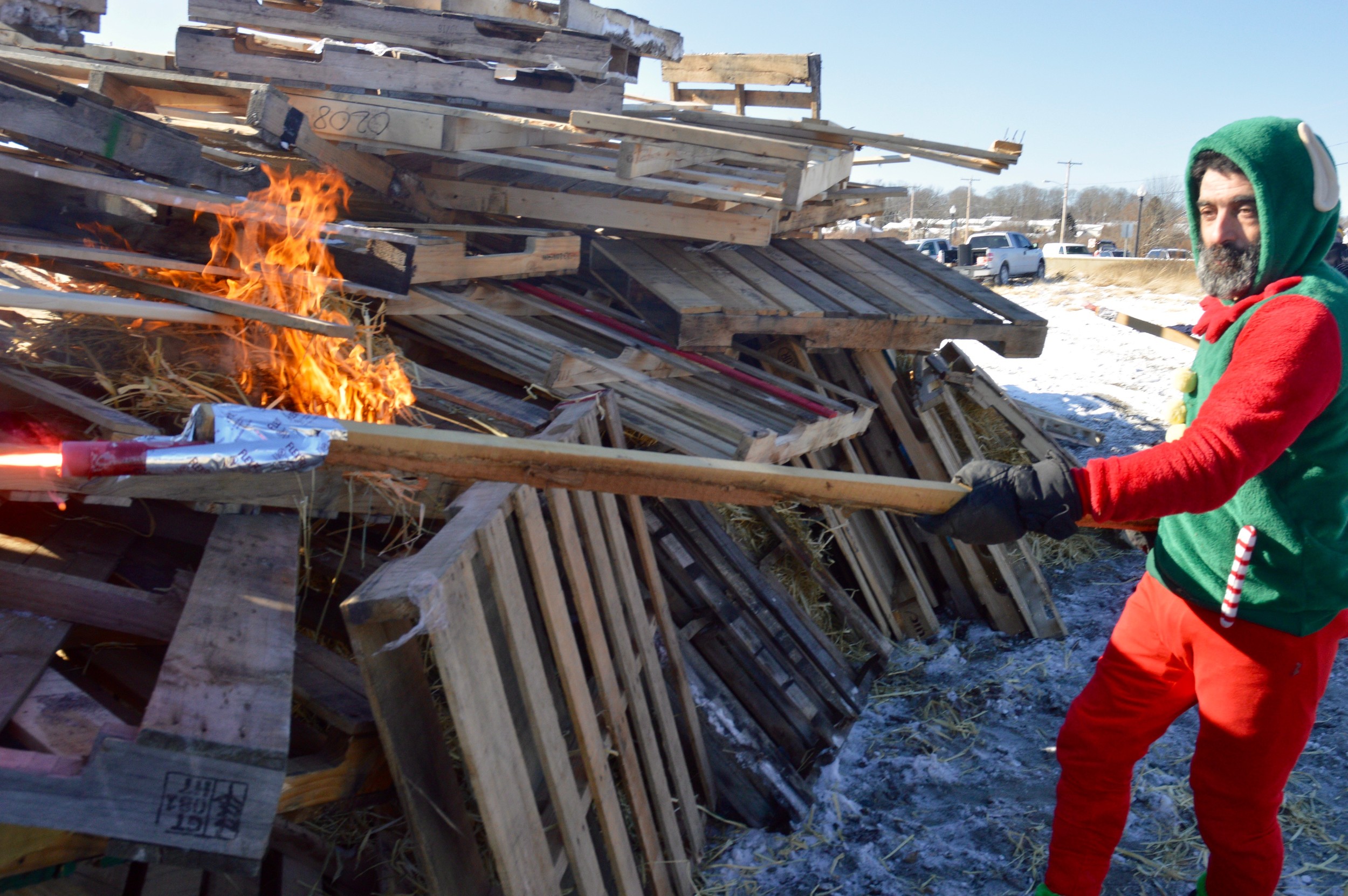 Before he jumped in himself, Chris Freitas helped light the bonfire, which used 402 pallets.