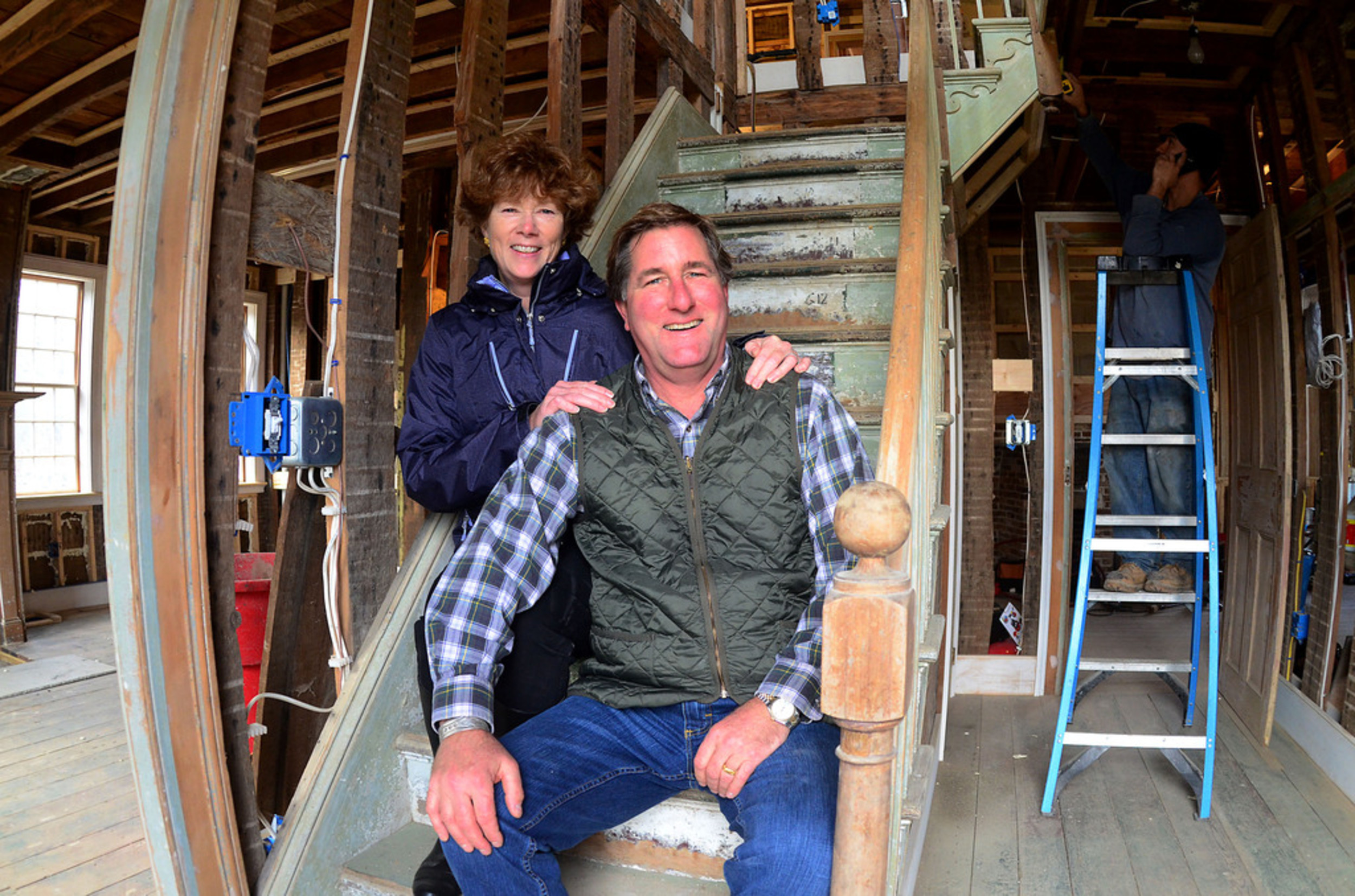 Dora Atwater Millikin and Trip Millikin sit on the main staircase of the 1835 house that they moved from Buzzards Bay Brewery to their Main Road property. Some of the posts and beams date back to an even earlier 1709 house.