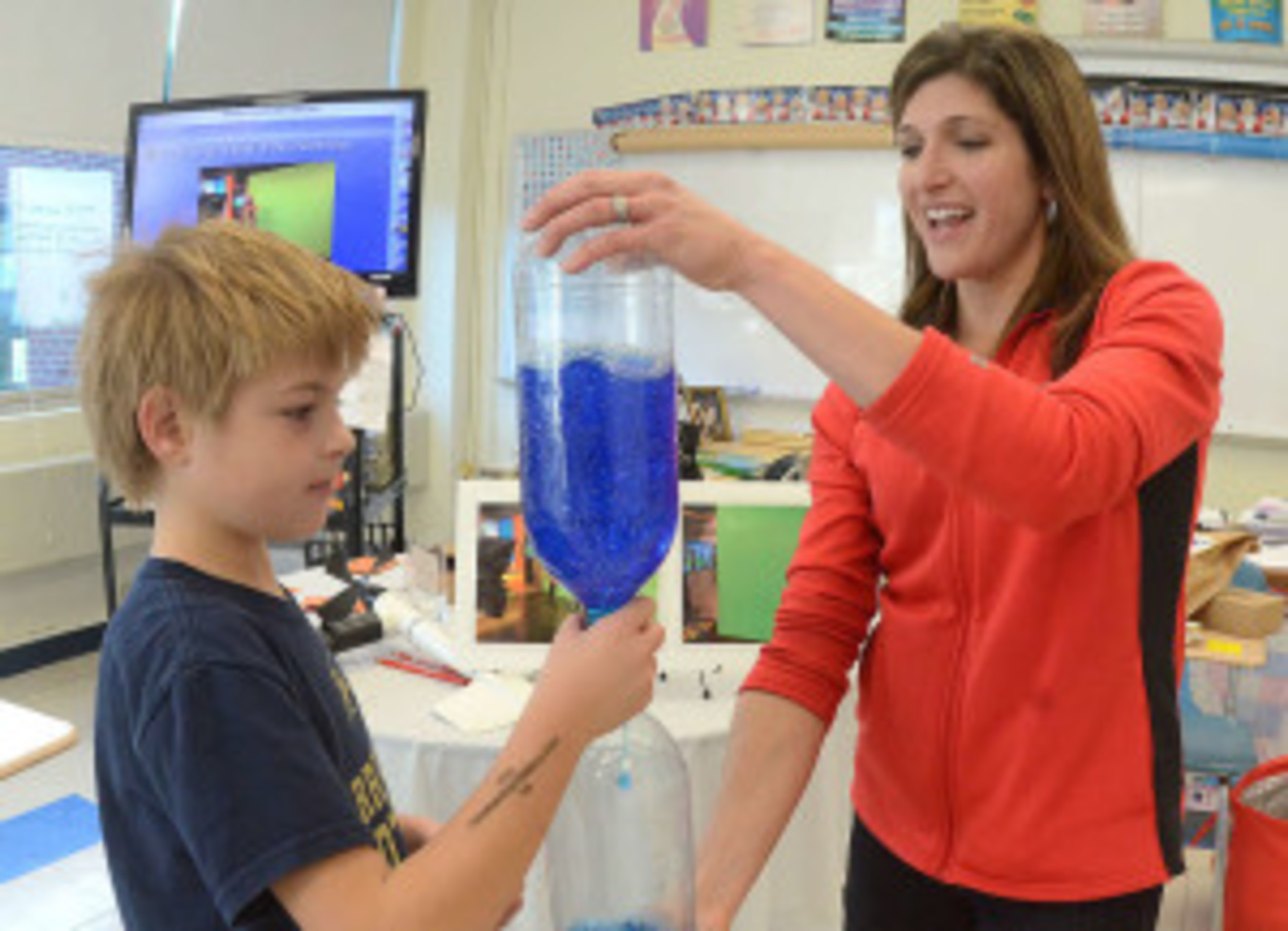 FOX Meteorologist Michelle Muscatello and Tyler Tomulonis, 7, make a twister in a bottle, at the BEF STEAM event.